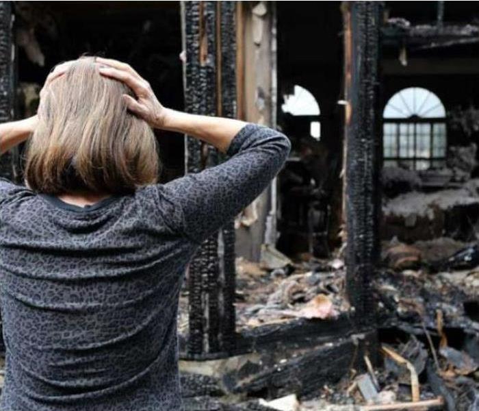 Woman Looking At Fire Devastation